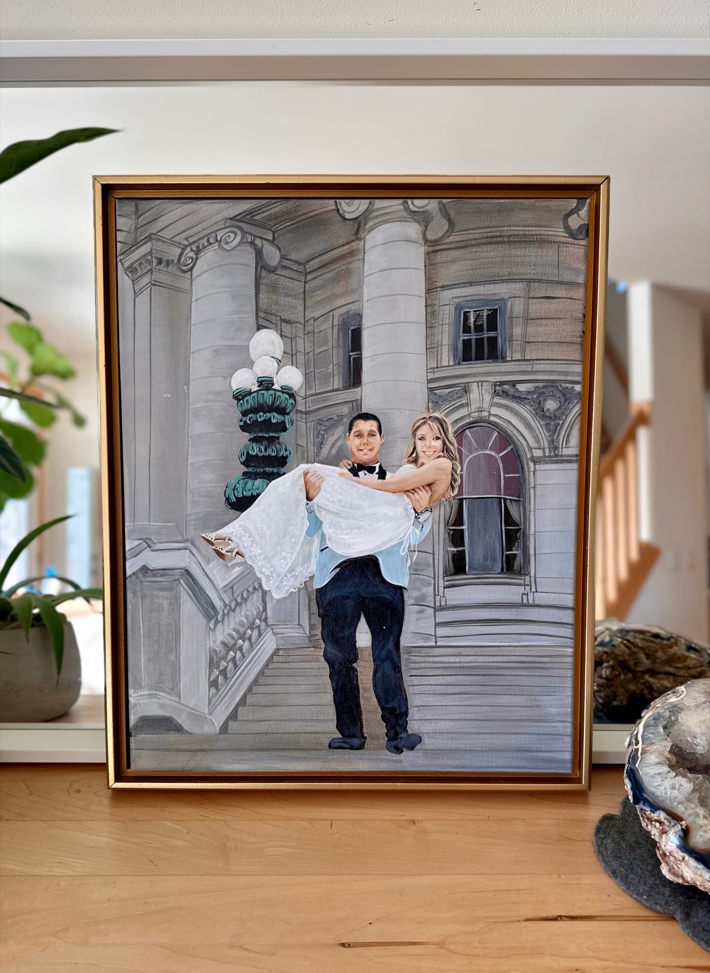 Capitol steps wedding painting on a wood console with houseplant beside the frame