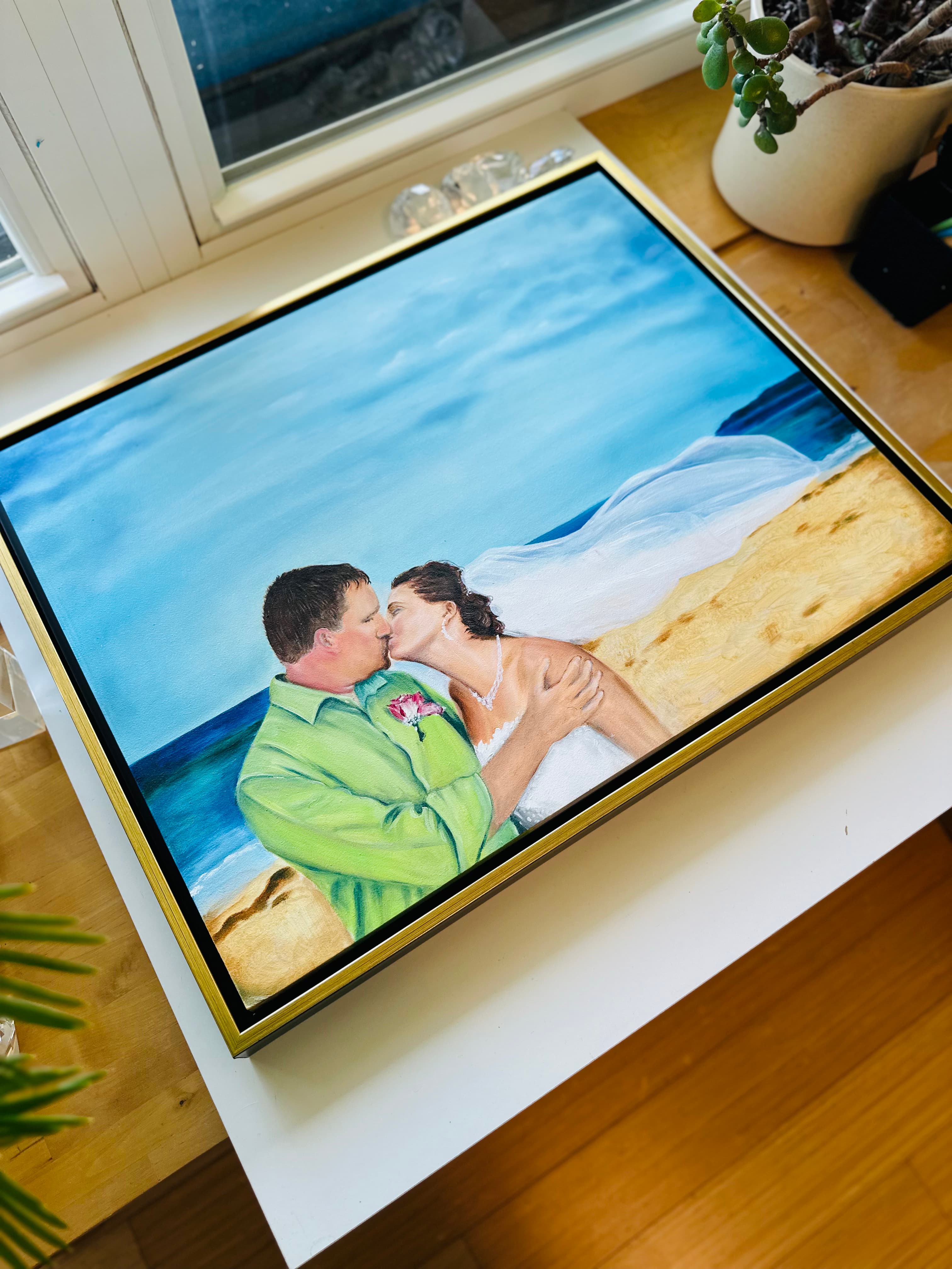 Seashore wedding painting seen from above on a table by the window