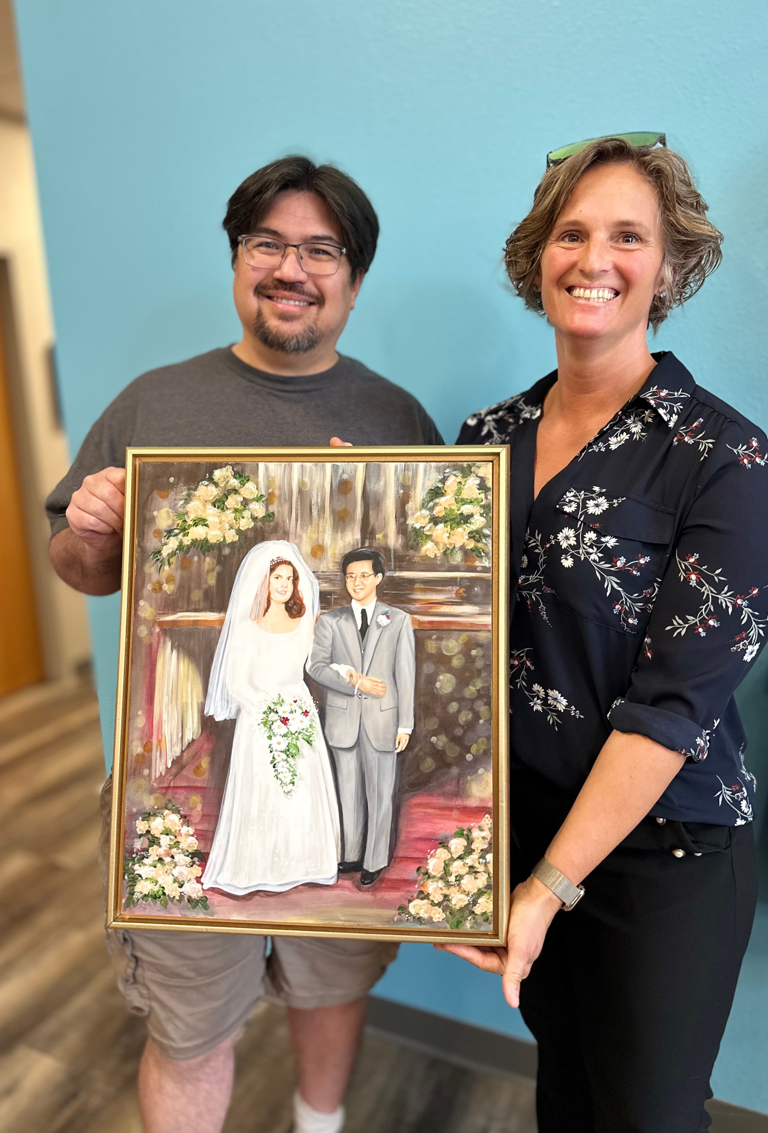 Brian and Kinga holding the finished 50th anniversary painting at a Chamber of Commerce event