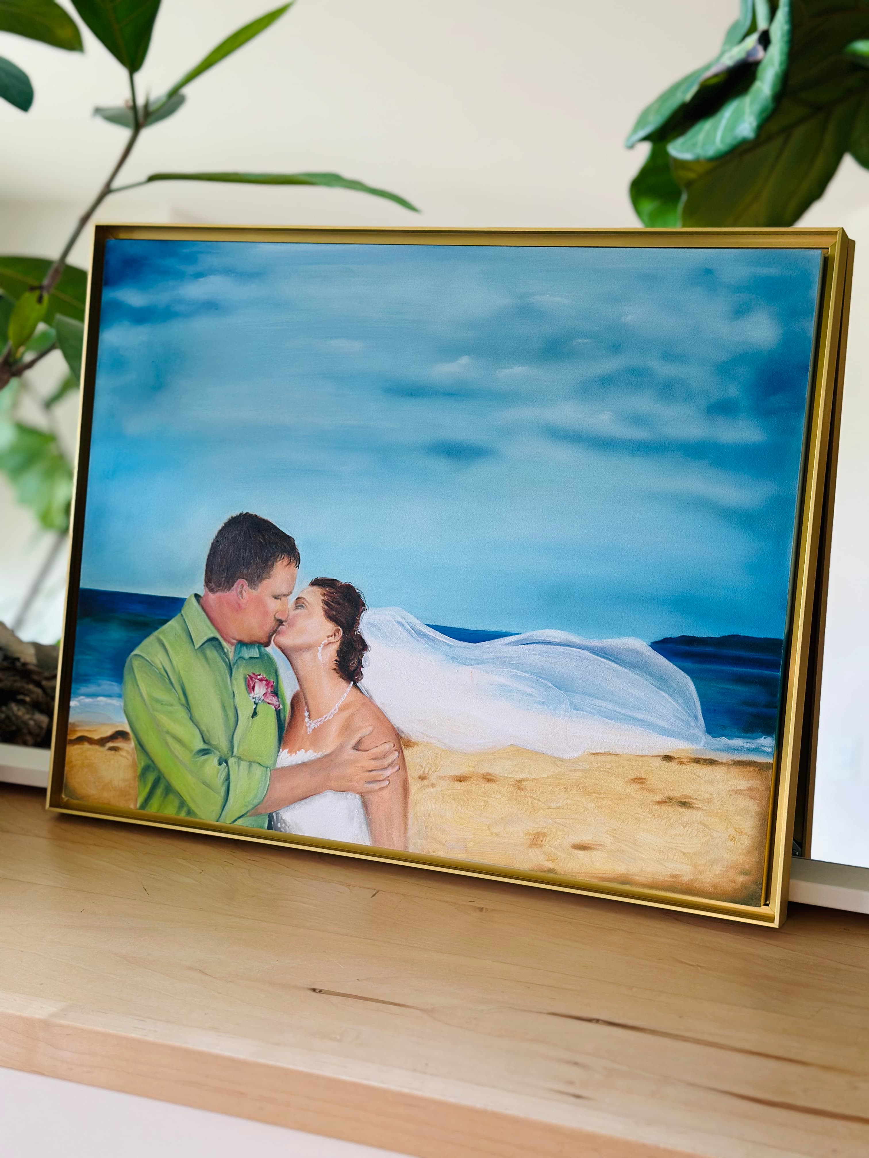 Seashore wedding painting propped on a shelf — veil sweeping over the sand and sea