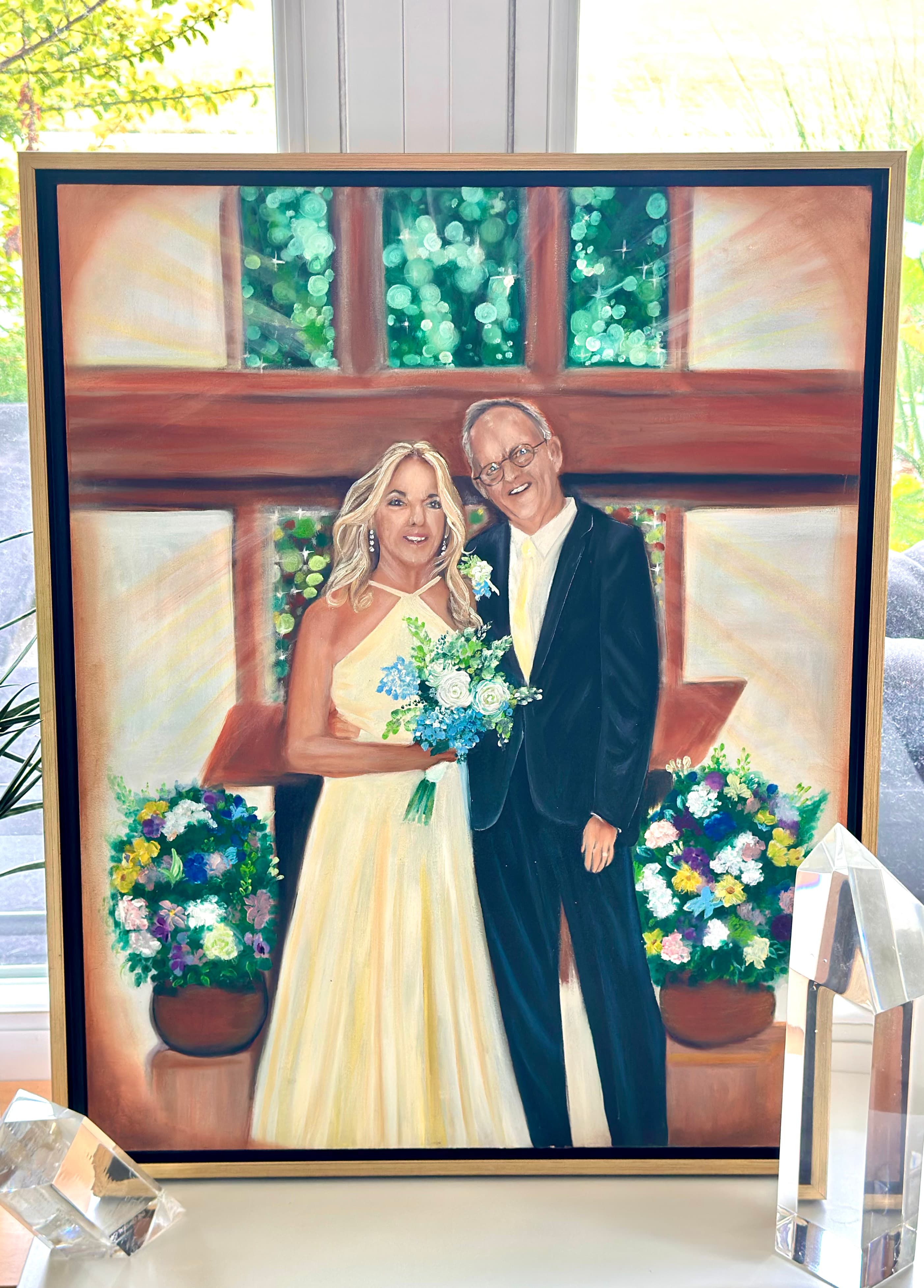 Church wedding painting — the couple with her bouquet before the green church windows, in a gold floater frame
